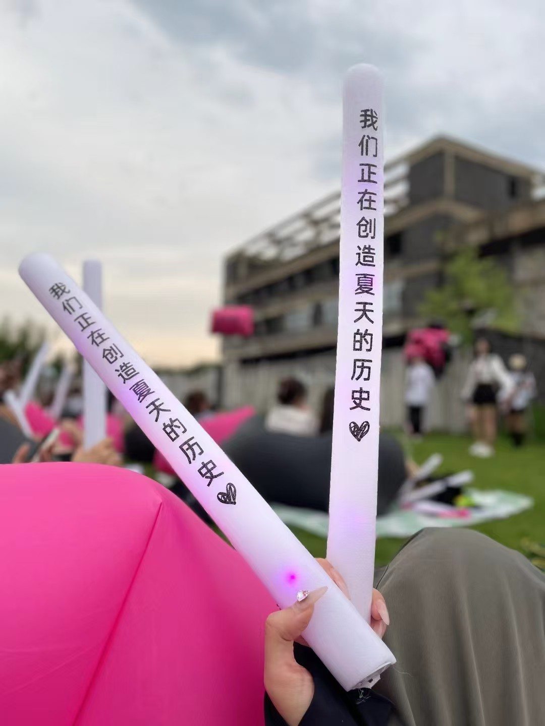 悦瘾音乐节户外活动现场,参与者手持粉色荧光棒
